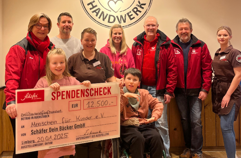Herzbrot-Spendenübergabe 2024 – 12.500 € für Menschen für Kinder e.V. Scheck über 12.500 € an Menschen für Kinder e.V., Gruppe mit Kindern.